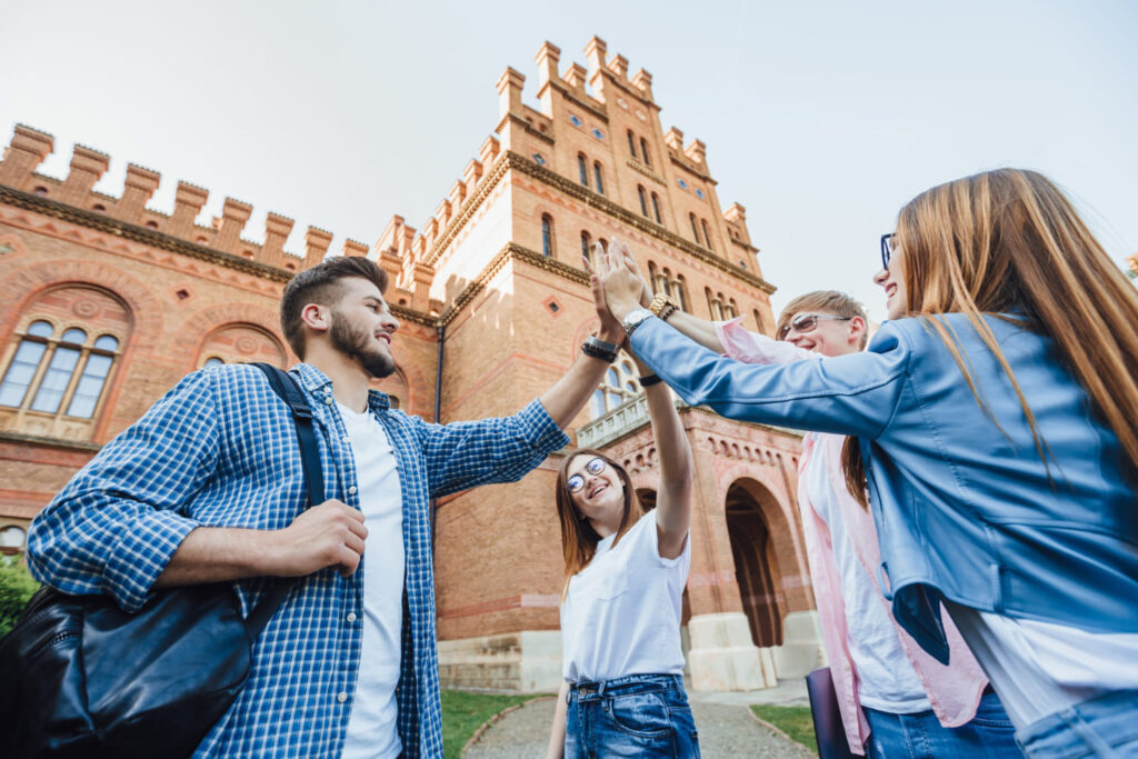 Estudantes em grupo felizes por participarem de um summer program (curso de verão) em universidade internacional.