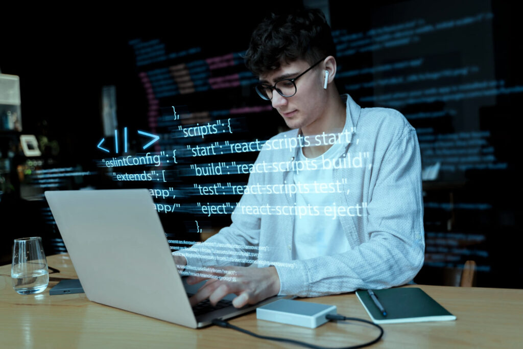 Programador trabalhando com códigos em um computador; entenda que é back-end e como ele se conecta com o front-end e o full stack