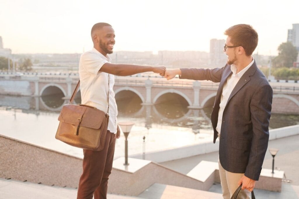 Dois homens se cumprimentando e sorrindo; Dia do Homem 2025: veja frases e porque é em 15/07 no Brasil