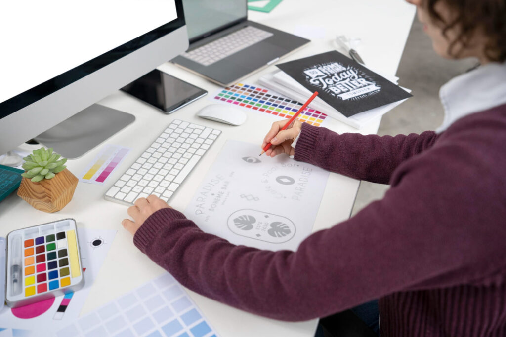 Designer gráfico trabalhando em um logo no computador; confira a diferença entre design gráfico e motion design