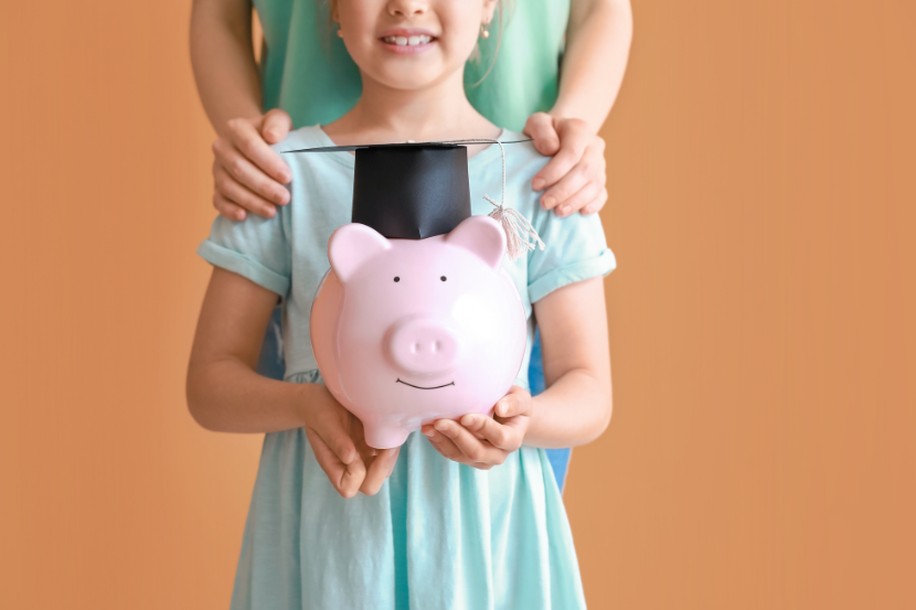 criança com porquinho na mão e mãe atrás, mostrando a importância da educação financeira.