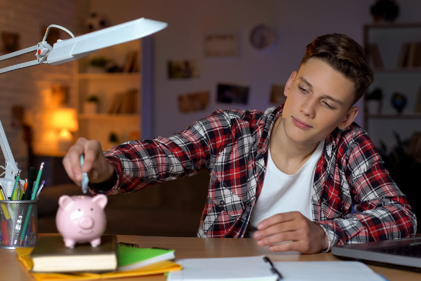 adolescente com educação financeira colocando dinheiro no cofrinho