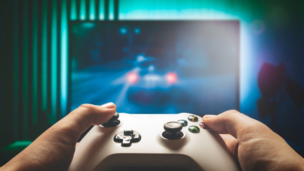 Jogador segurando um controle de videogame. A imagem representa o campo do Design de Games.