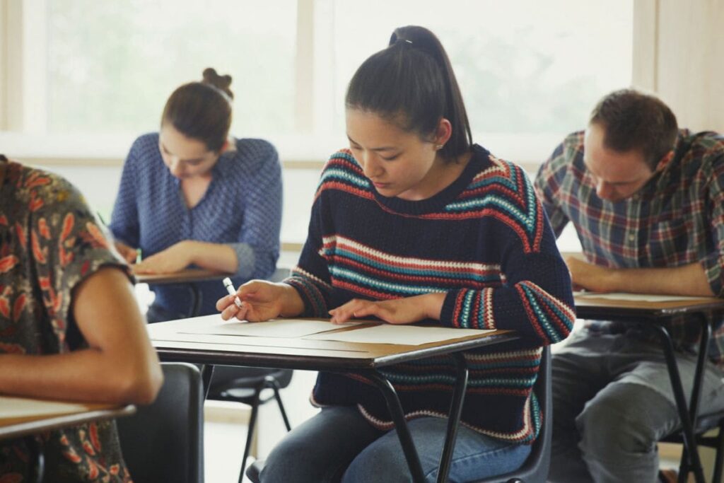 Candidatos fazendo prova de concurso em sala de aula; veja qual nota é preciso tirar para ser aprovado no CNU 2025