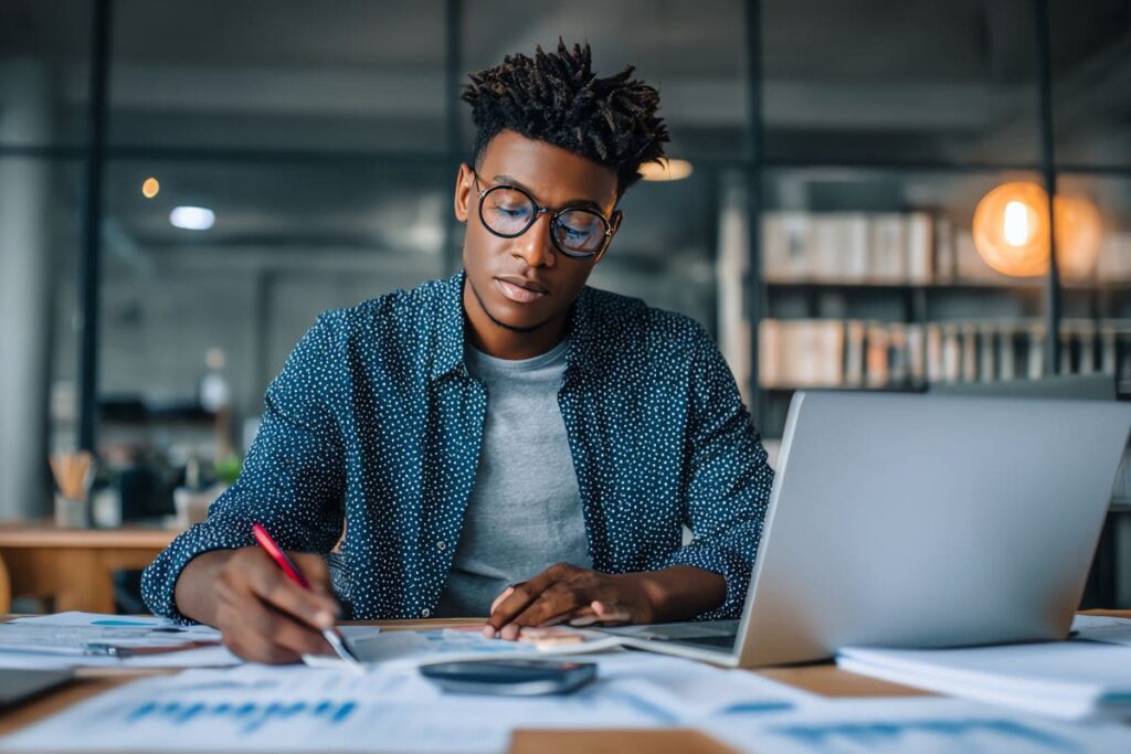 Funcionário de empresa analisando gráficos financeiros em laptop