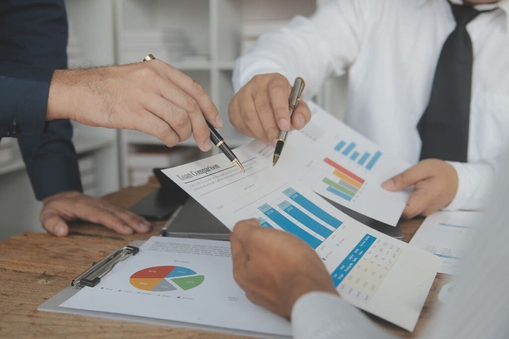 Equipe analisando relatórios financeiros em reunião.