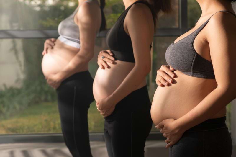 Mulheres grávidas praticando exercícios de fisioterapia, com foco no cuidado e bem-estar da saúde da mulher durante a gestação.
