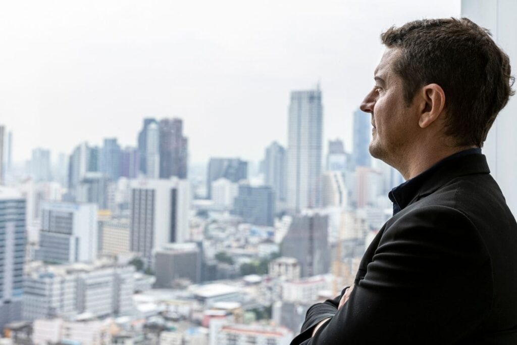 CEO observando a cidade enquanto reflete sobre decisões estratégicas