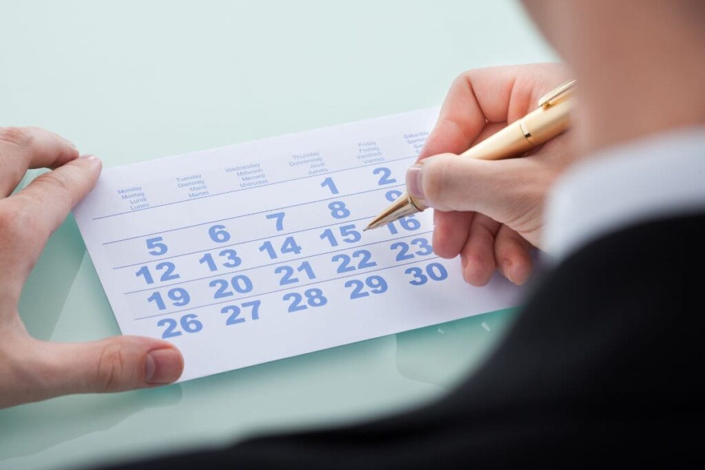 Pessoa analisando calendário e marcando dia 15 de novembro; veja se 15 de novembro é feriado e confira quem tem direito à folga