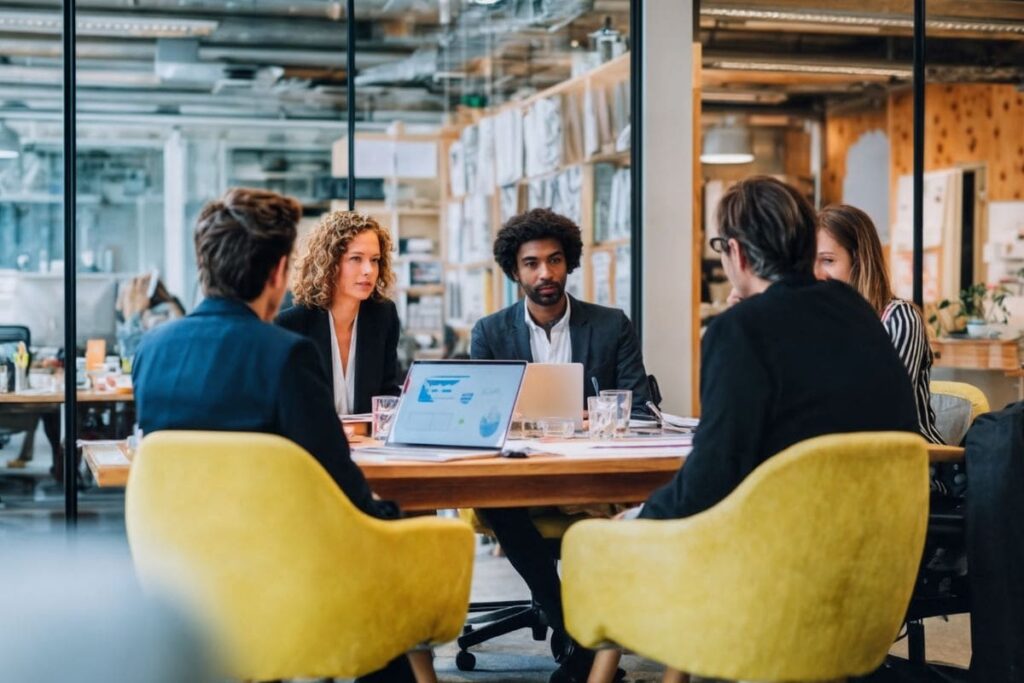 Time de profissionais de uma startup reunido conversando sobre estratégias de growth