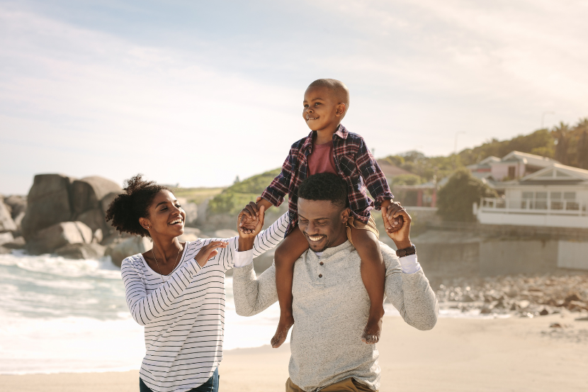 família caminhando na praia em passeio gratuito nas férias escolares
