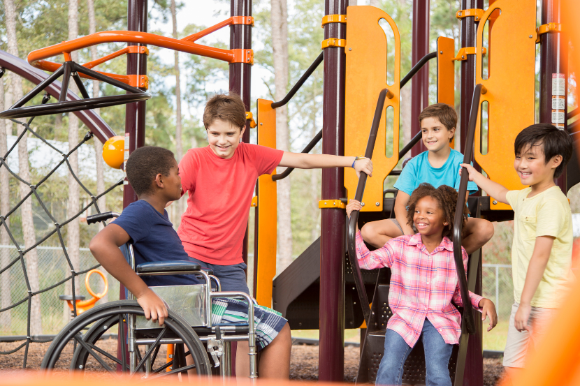 crianças com e sem deficiência brincando juntas no parquinho
