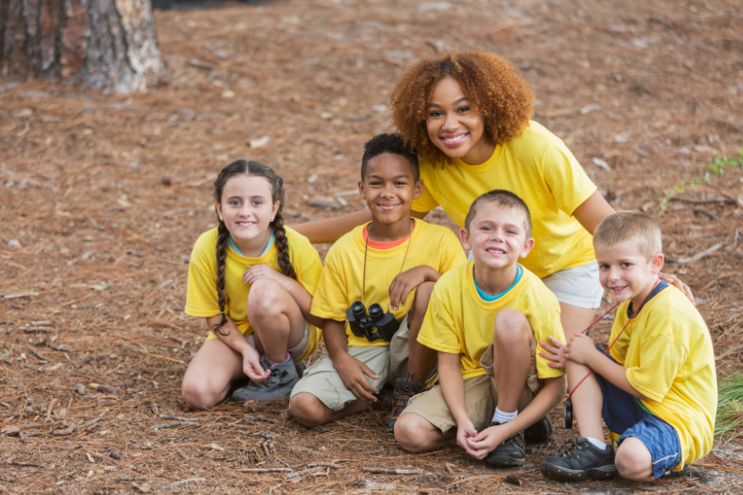 crianças com monitora em acampamento de férias