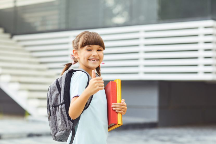 criança sorrindo com material escolar iniciando ano letivo 2026