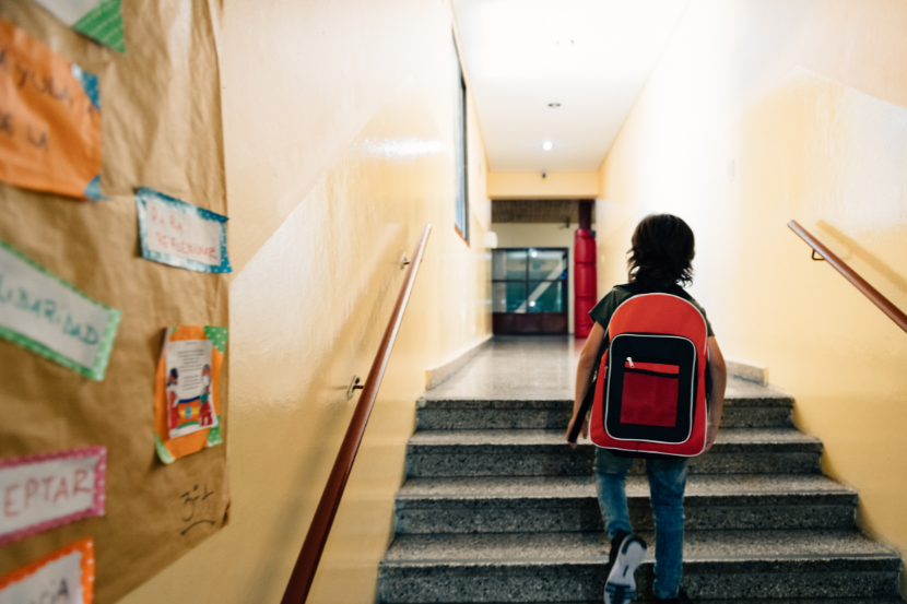 criança sozinha entrando na escola