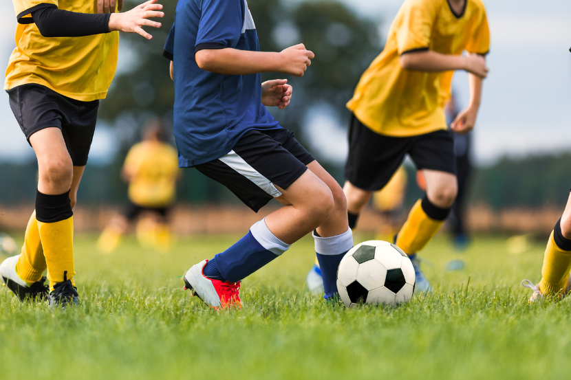 crianças treinando futebol como atividade extracurricular