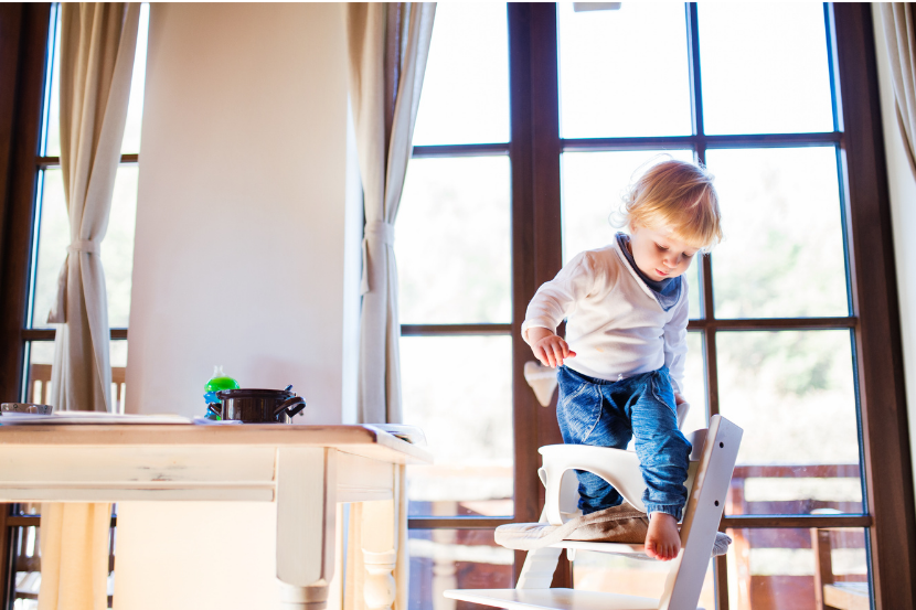 criança saindo da cadeira sozinha com risco de acidente de queda