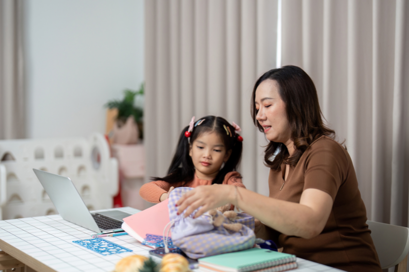 mãe ajudando a organizar material escolar da filha para a volta às aulas