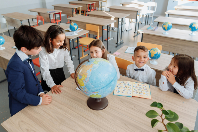 crianças na escola com livro e globo terrestre celebrando a educação