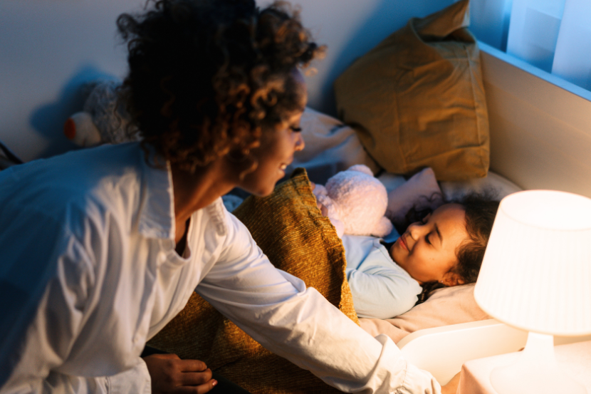 mãe colocando criança para dormir ajuste de rotina