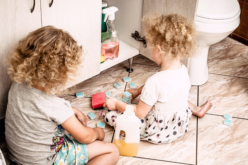 crianças mexendo em produtos de limpezas perigosos para acidentes domésticos