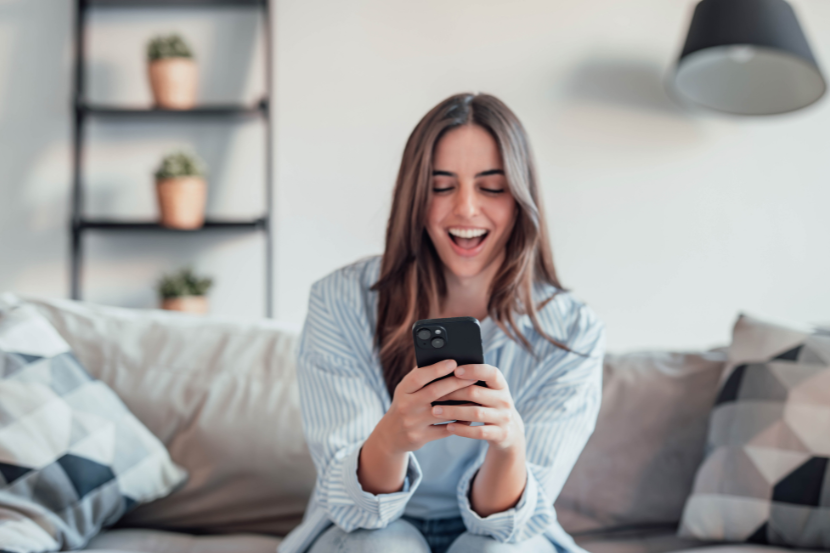 menina animada olhando para o celular 