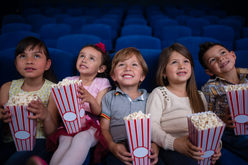 crianças no cinema comendo pipoca na semana do cinema 2026