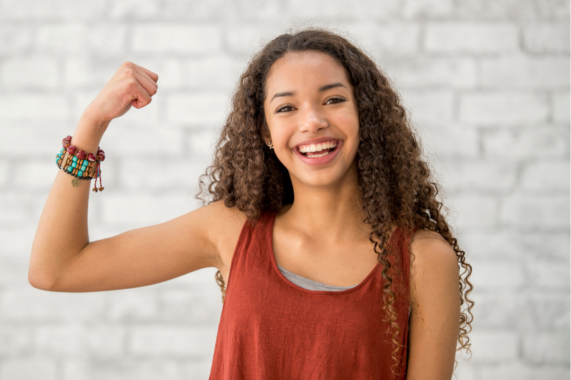 adolescente fazendo gesto de força no dia da mulher
