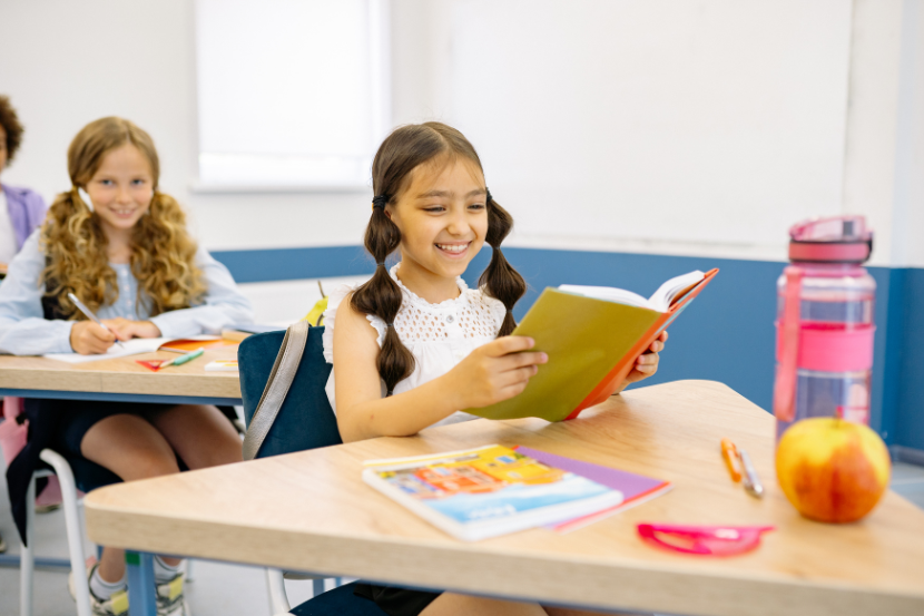criança alfabetizada em sala de aula lendo e escrevendo