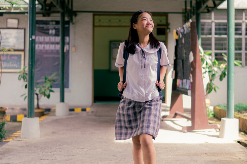 aluna sorridente chegando na escola representando preparação para medicina no ensino médio