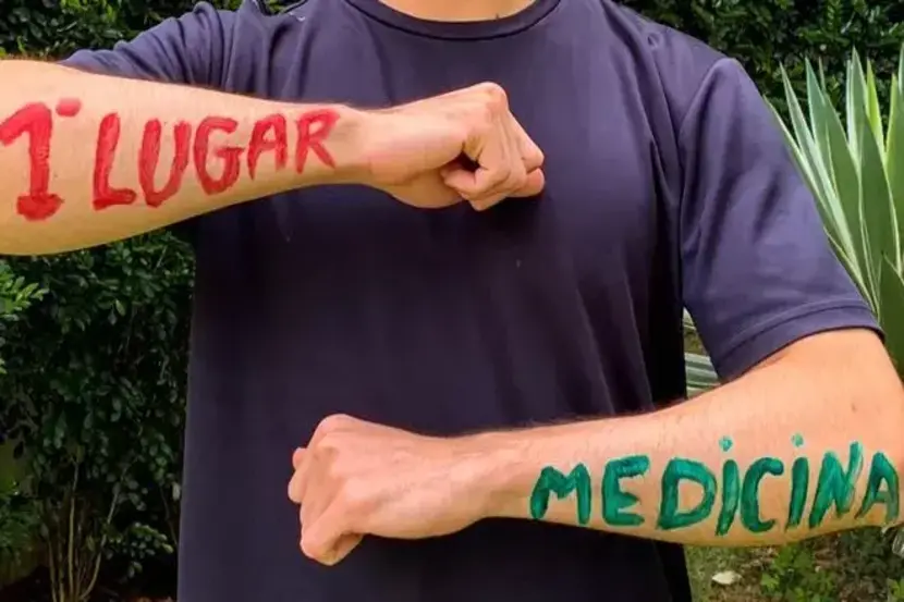 aluno com braço pintado mostrando aprovação de 1 lugar em medicina no ensino médio