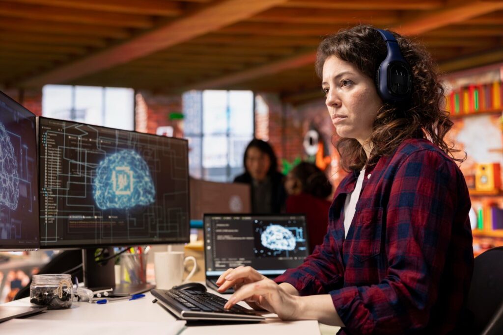 Estudante de ciência da computação programando em computador com códigos e interface de inteligência artificial na tela.