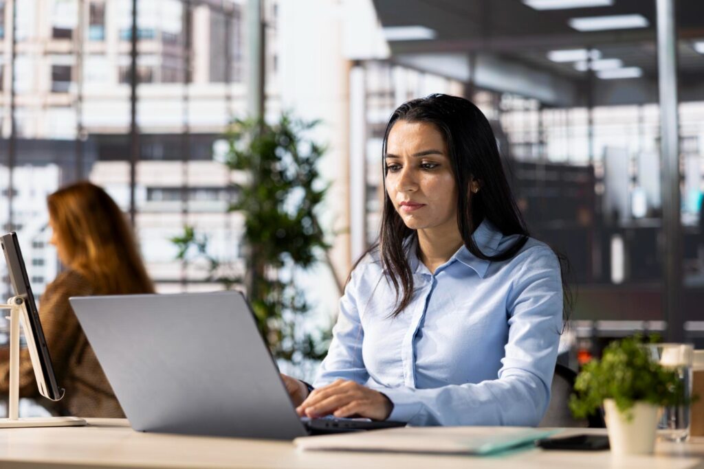 Estudante de Ciência da Computação em ambiente corporativo (escritório) realizando estágio obrigatório da faculdade.