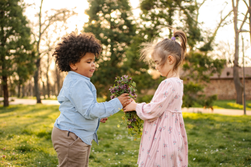 criança entregando flor para outra no dia do amigo