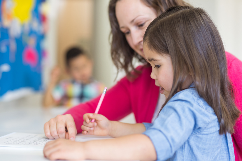professora praticando atividades de caligrafia com aluna
