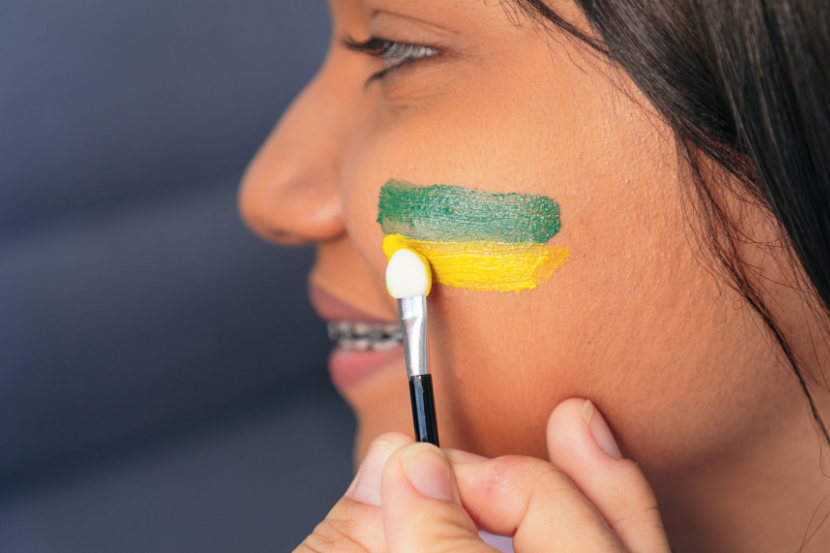menina pintando o rosto em clima de copa do mundo