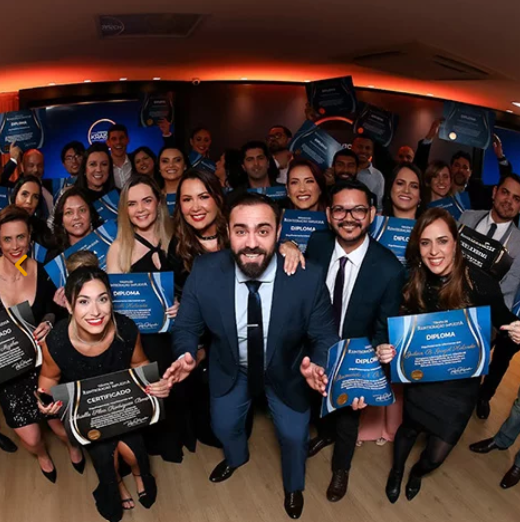 Rafael Kraisch e grupo de alunos do Instituto Kraisch posando para foto mostrando seu diploma durante a formação de terapeutas.