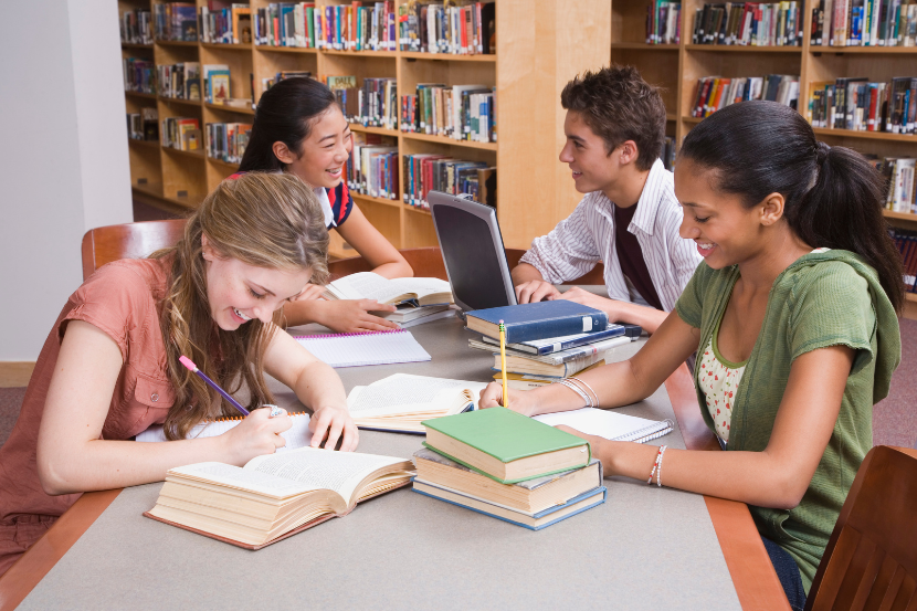 alunos estudando para a olimpíada de português 2026 na biblioteca