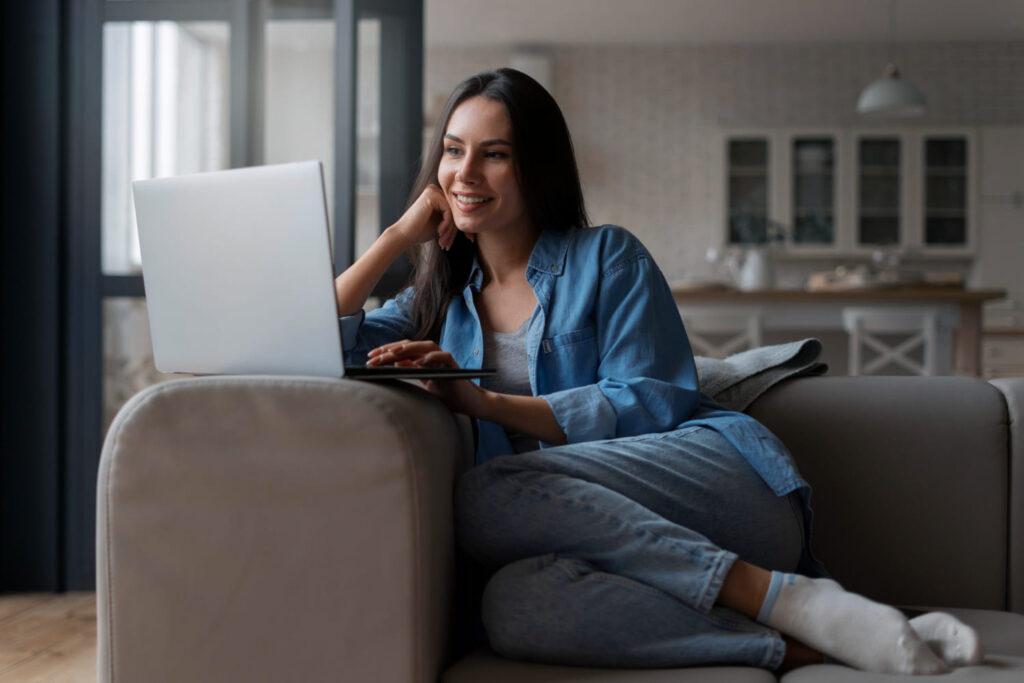 Jovem mulher trabalhando no formato home office na sala de sua casa; veja 7 cursos técnicos para trabalhar de home office