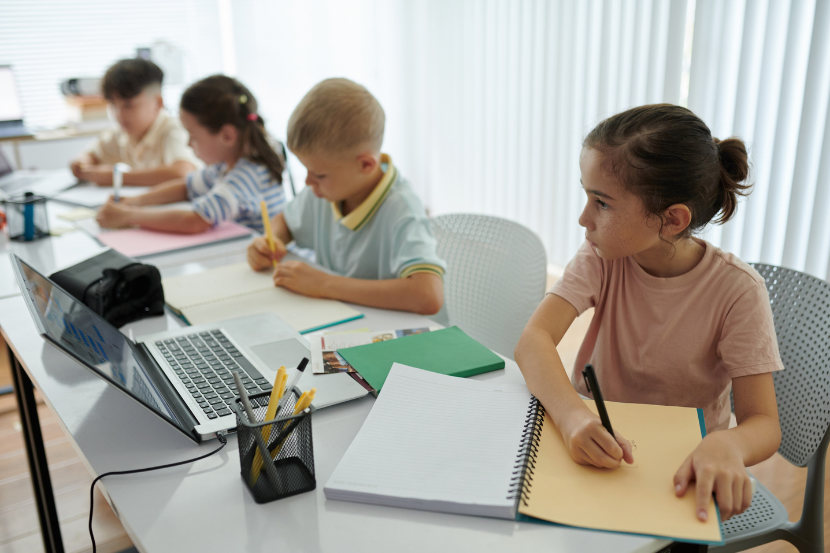 crianças menores estudando com caderno e computador