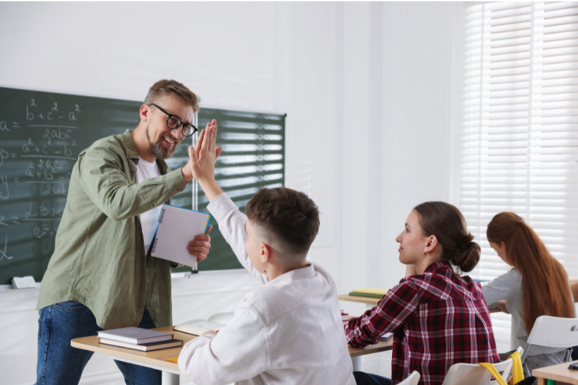 professor parabenizando aluno em sala de aula por resposta certa em matemática
