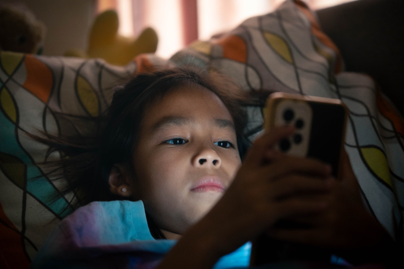 criança concentrada mexendo no celular