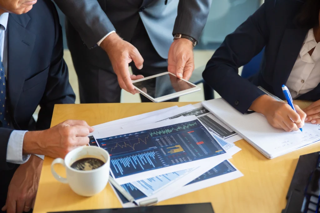 Profissionais de finanças corporativas reunidos ao redor de uma mesa.