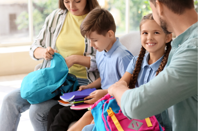 pais ajudando filhos a arrumar material para nova escola com bolsa de estudo