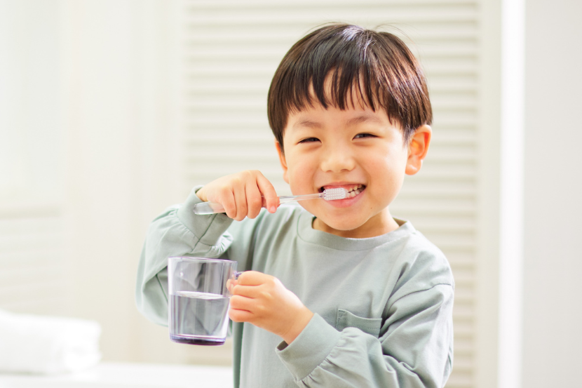 criança economizando água ao escovar os dentes