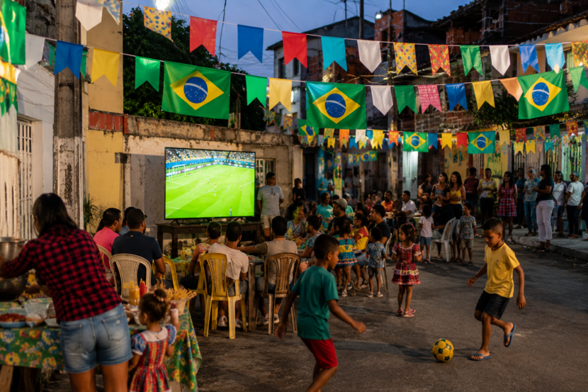 vizinhança toda envolvida em uma festa junina com tema da copa do mundo durante jogo do Brasil