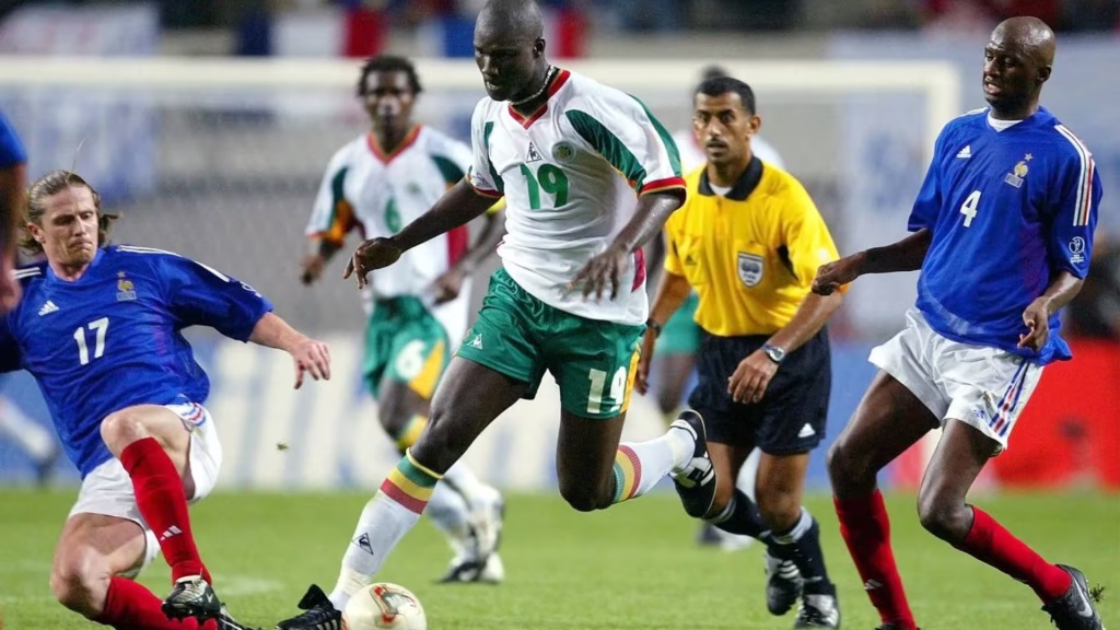 Jogadores de França e Senegal disputam a bola durante partida da Copa do Mundo de 2002, vencida pela seleção senegalesa por 1 a 0.