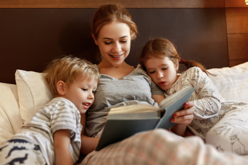 mãe lendo livro para crianças durante rotina nas férias