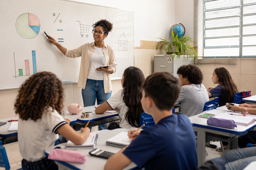 professora em sala de aula ensinando educação financeira na matemática