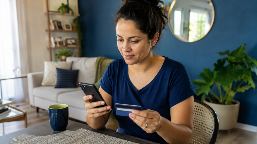 Mãe organiza gastos da rotina e consulta benefícios pelo celular e notebook.